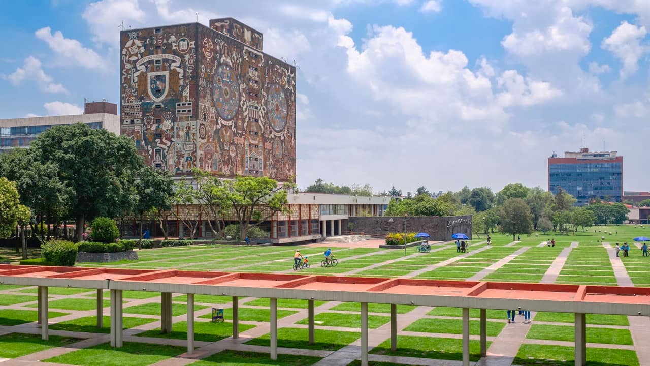 Ante la próxima reanudación de actividades administrativas en la máxima casa de estudios, la Universidad Nacional Autónoma de México (UNAM) regresó al uso de cubrebocas, esto debido el ascenso gradual en los casos de COVID-19, reportados desde el mes de junio. Señaló que, de acuerdo con datos de la Dirección General de Epidemiología, la positividad a COVID-19 refleja una tendencia de ascenso gradual; y las entidades con mayor número de casos son: Ciudad de México Querétaro Estado de México Nuevo León Puebla UNAM reitera uso de cubrebocas en reanudación de actividades Recordó que en la última semana de julio será cuando se reanuden actividades administrativas y, para evitar contagios, así como proteger a personas vulnerables, reiteró: Uso de cubrebocas en lugares cerrados. Evitar contagios de enfermedades respiratorias. Si hay malestar físico que sugiera infección respiratoria se recomienda permanecer en casa. Aplicarse dosis de refuerzo contra influenza, neumococo y COVID-19 de pertenecer a grupos de riesgo. Ventilación de aulas, auditorios y sitos de reunión. Cuando se presenten casos de enfermedad coincidentes en un grupo académico o área de oficina, no suspender actividades y extremar precauciones. Situación actual de COVID-19 en México La Secretaría de Salud federal informó, que suman 388 defunciones y 8 mil 540 casos de COVID-19 en el país, en lo que va del 2024. En la última semana, fueron 13 defunciones a causa de la enfermedad viral, pero no hay incrementos. Los contagios sí muestran ascenso, con 465 casos. En su informe epidemiológico semanal, la dependencia reporta un ascenso gradual de casos desde hace dos meses, del 5 de mayo hasta la semana actual. Como dato preliminar, el informe registró un 30% en la positividad de casos COVID. Sin embargo, la Secretaría de Salud detalla que, en comparación con 2023, en el mismo lapso, se reporta un 41% menos de casos, es decir, no se registran más contagios que el año pasado en estas mismas fechas.