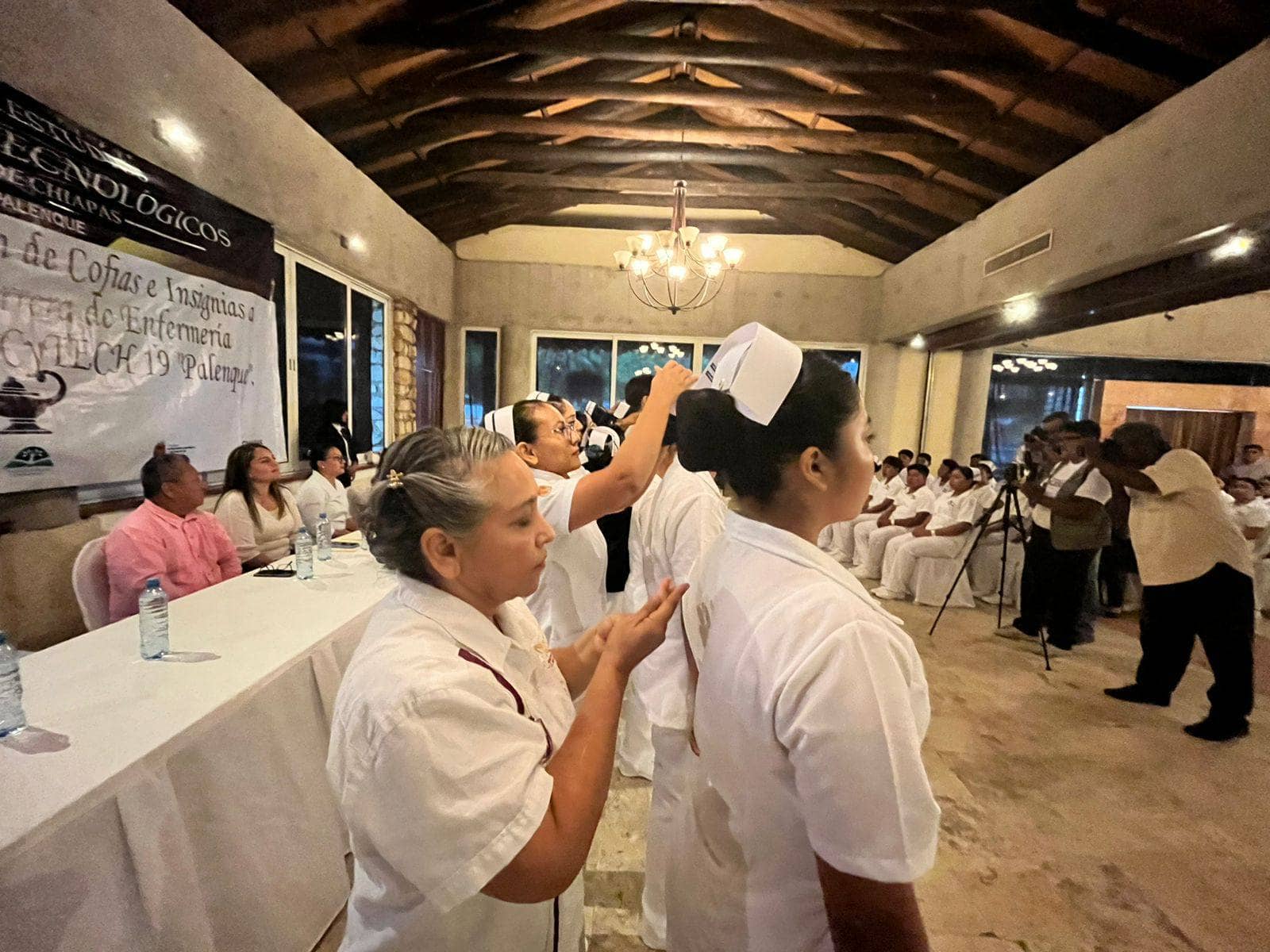 Con la finalidad de reconocer el esfuerzo y la responsabilidad social que asumirán los estudiantes de la carrera técnica en Enfermería General del Colegio de Estudios Científicos y Tecnológicos del Estado de Chiapas (Cecytech) plantel 19, ubicado en el municipio de Palenque, se llevó a cabo el evento de imposición de cofias e insignias. Este acto fue presidido por el coordinador de la zona Maya, Reynerio Guzmán López, en representación del director general del Cecytech, Luis Guadalupe Morales Ángeles, evento que marca un momento significativo en la formación profesional de los futuros enfermeros y enfermeras. Acompañado por la directora del plantel, Alejandra Páramo Hernández, estudiantes, madres y padres de familia, Guzmán López expresó su reconocimiento a quienes iniciarán sus prácticas clínicas en diversas instituciones del sector salud. “Este paso es fundamental en su preparación, ya que les permitirá aplicar los conocimientos adquiridos en el aula a situaciones reales de atención médica